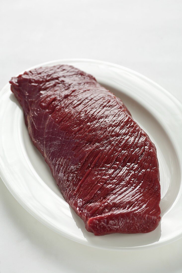 Raw fillet of venison on white plate