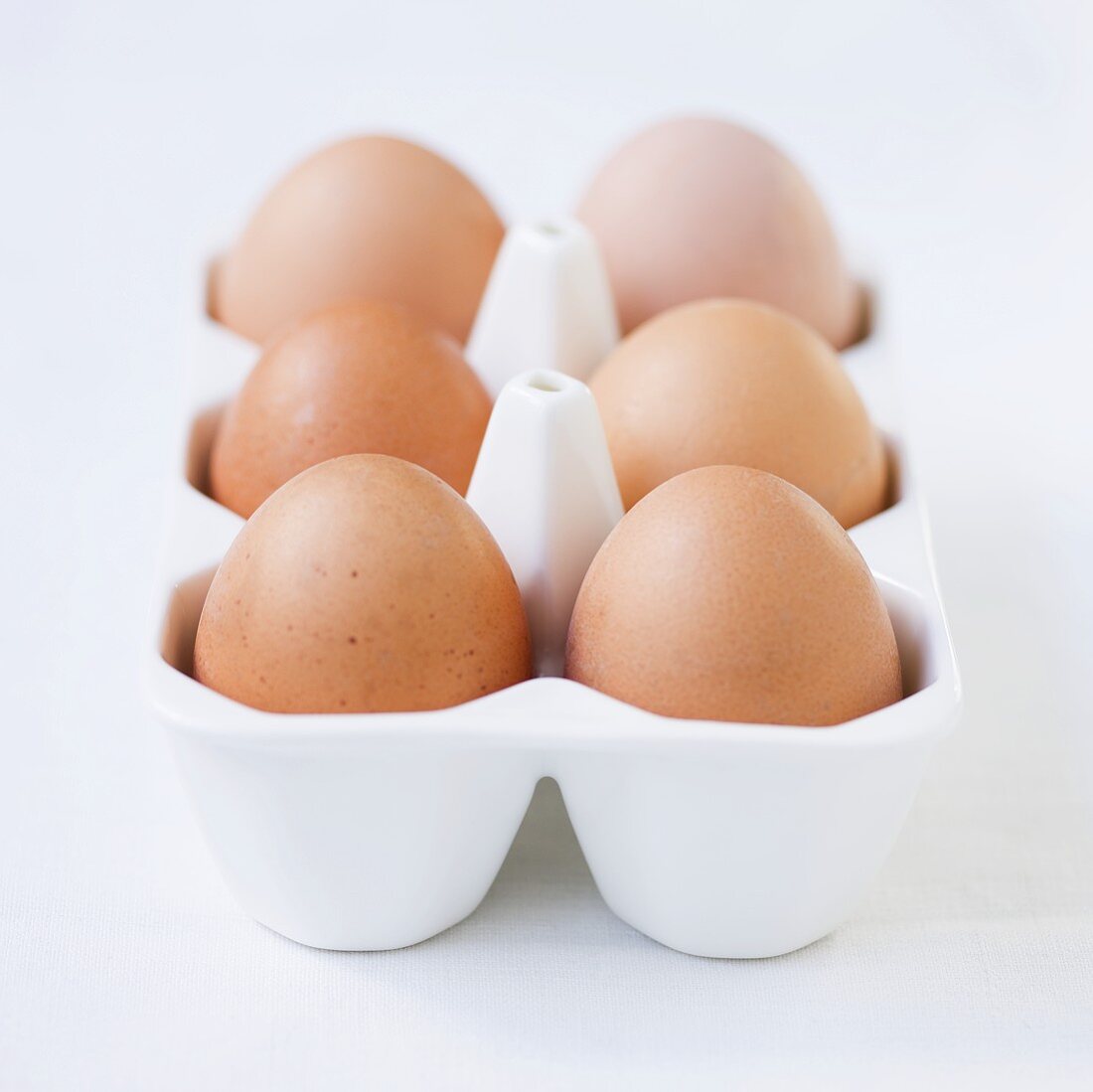 Frische Eier im Eierbehälter aus Porzellan