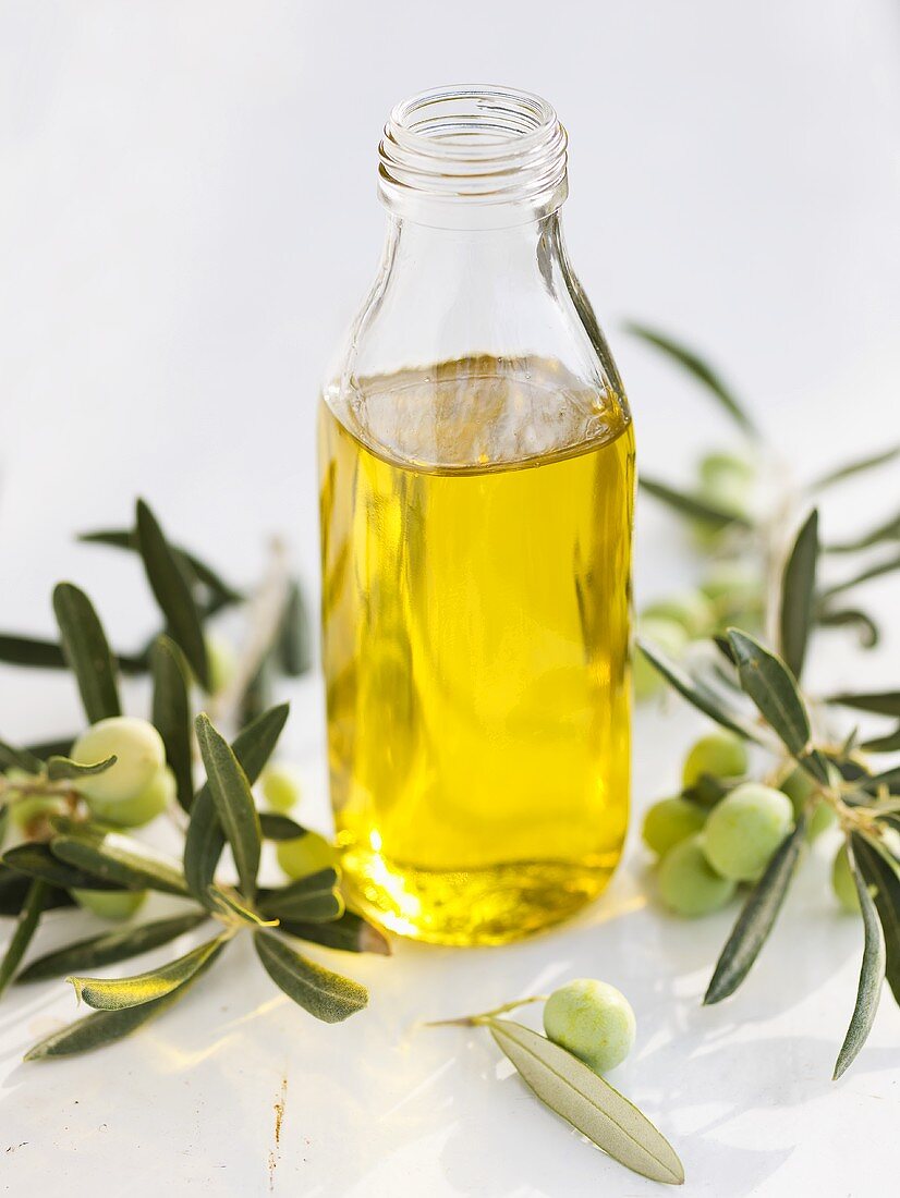 Ein Flasche Olivenöl mit Olivenzweigen