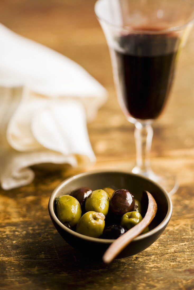 Marinierte Kalamata-Oliven und Glas Rotwein