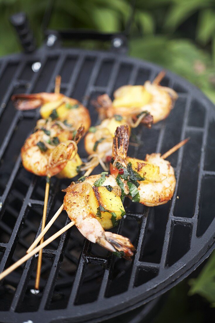 Three scampi skewers on a barbecue