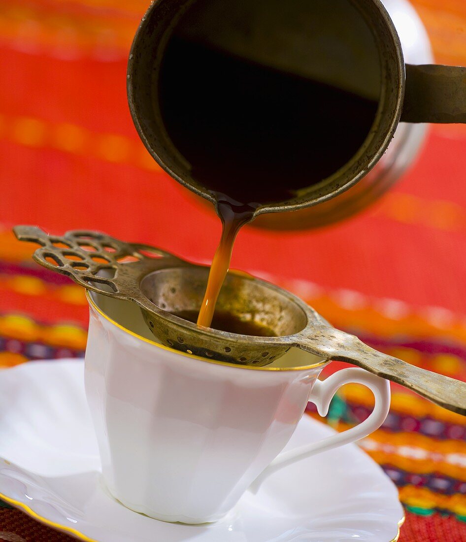 Pouring Turkish coffee through a strainer
