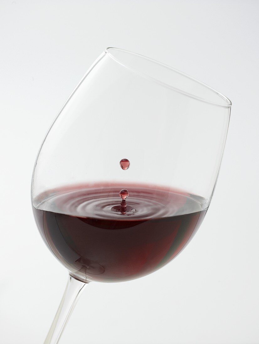 Rotweinglas mit Weintropfen