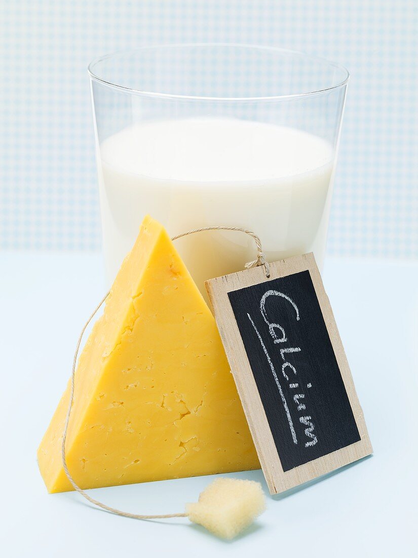 Cheddar cheese, milk and slate board with the word Calcium