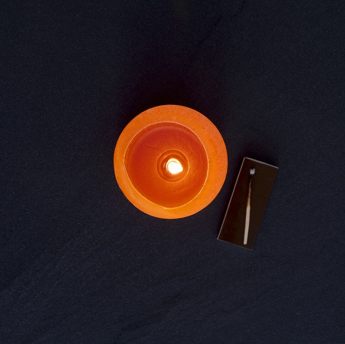 Orangefarbene Kerze (Draufsicht)