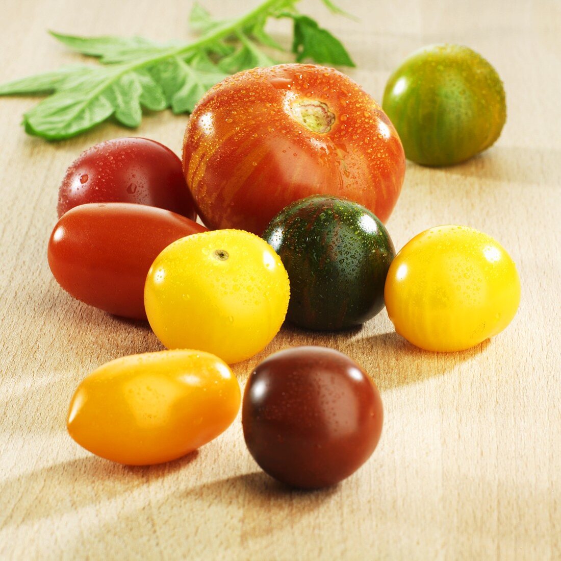 Various types of tomatoes with drops of water