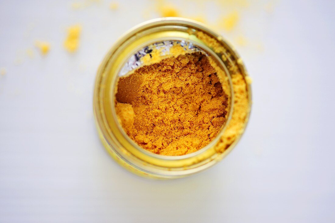 An opened tin of mustard powder