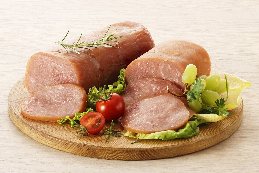 Turkey ham, partly sliced with salad and grapes