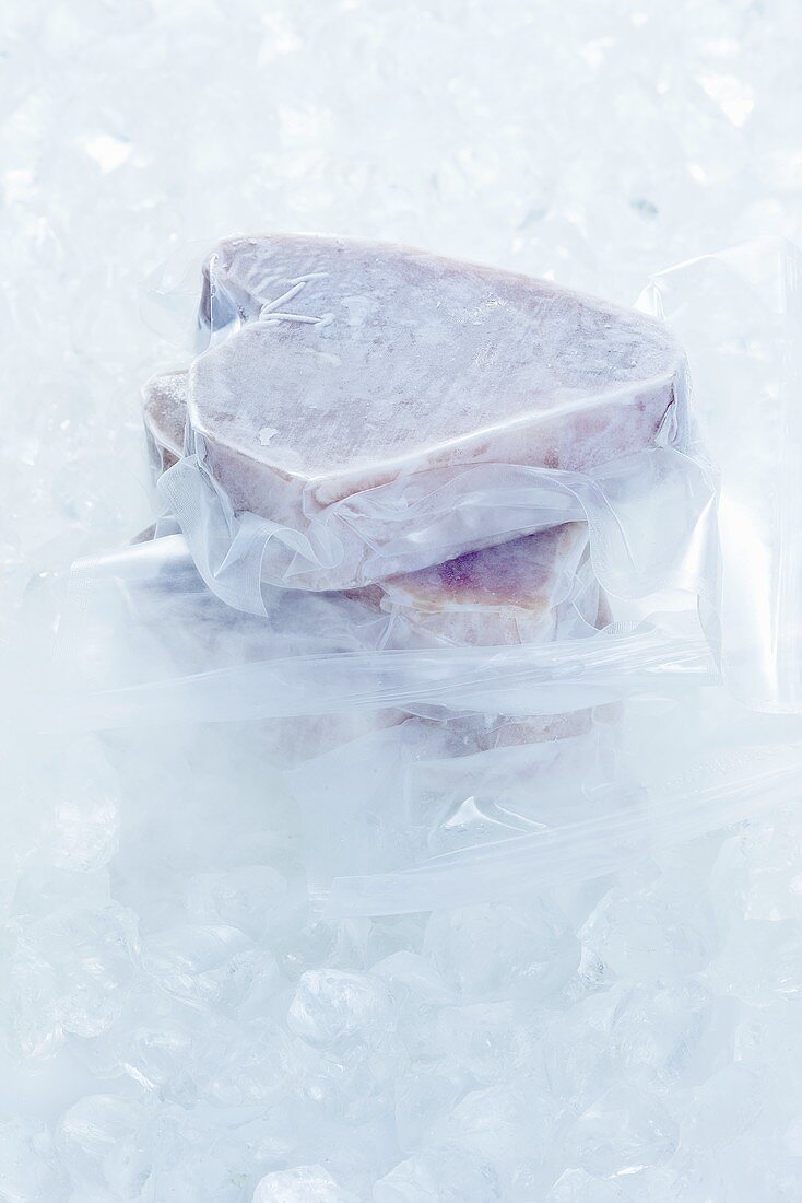 Frozen tuna steaks on ice