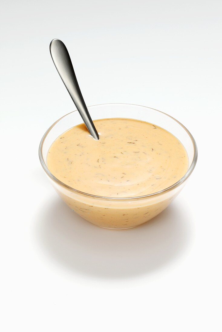 French dressing in a glass dish with spoon