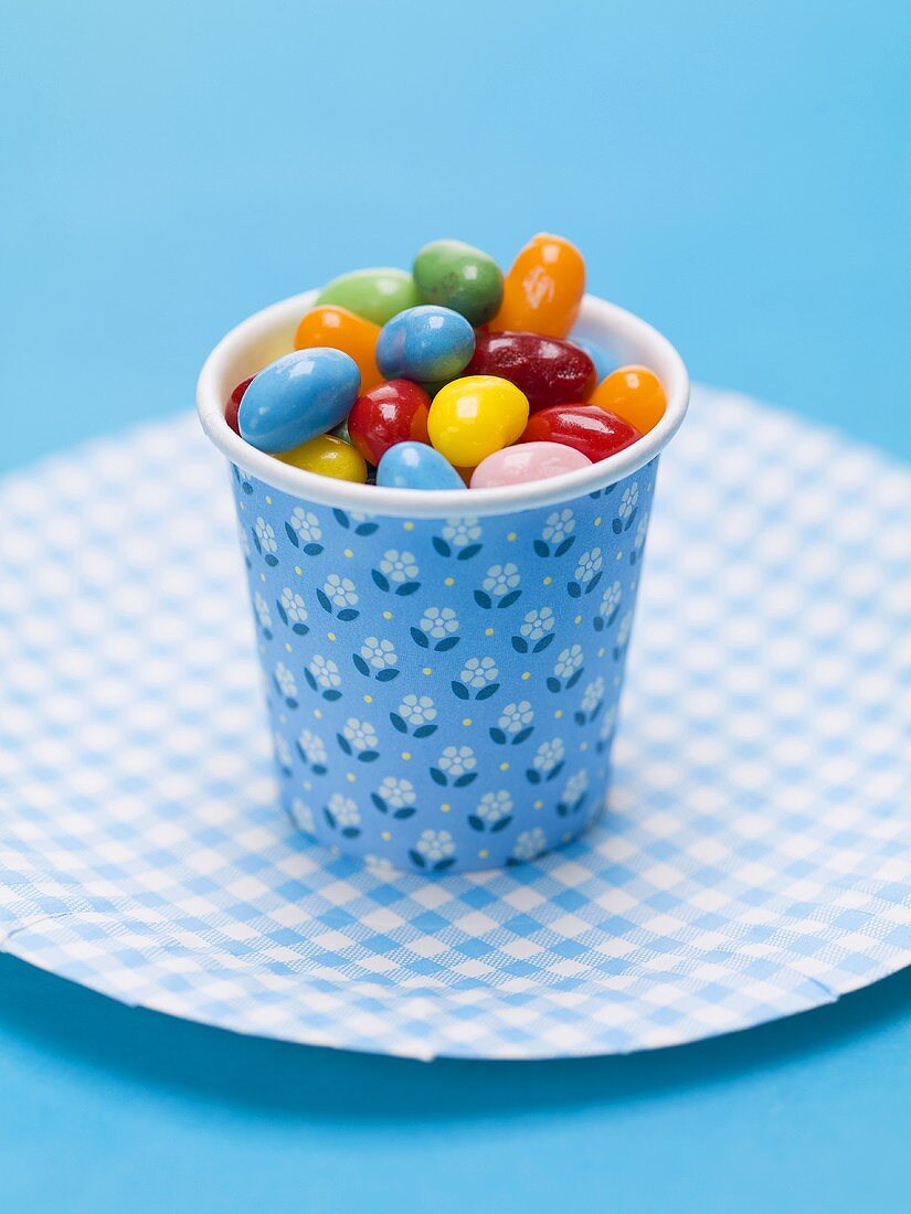 Jelly beans in a beaker on paper plate