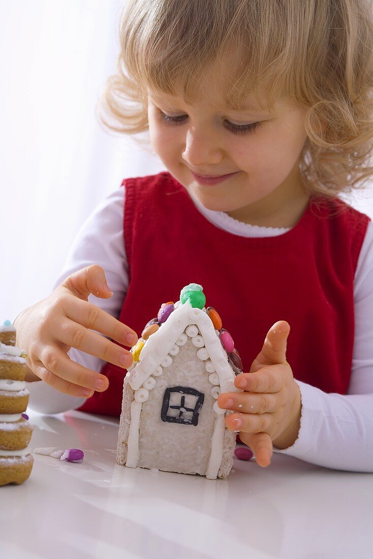 Kleines Mädchen mit verziert ein Lebkuchenhaus