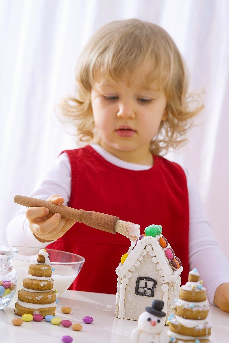 Kleines Mädchen mit verziert ein Lebkuchenhaus