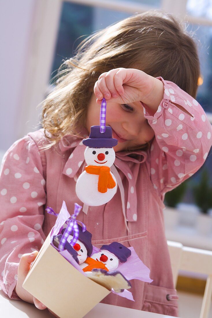 Girl holding salt dough snowman (tree ornament)