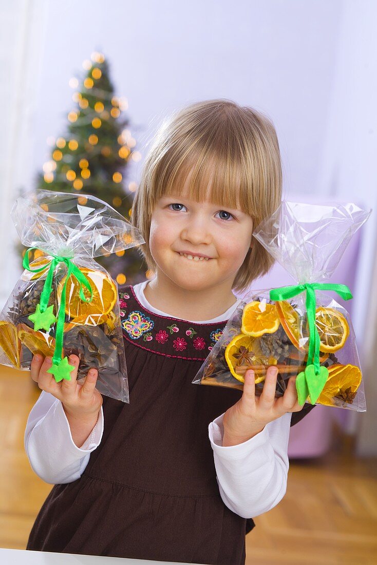 Kleines Mädchen mit Weihnachts-Potpourri in der Hand