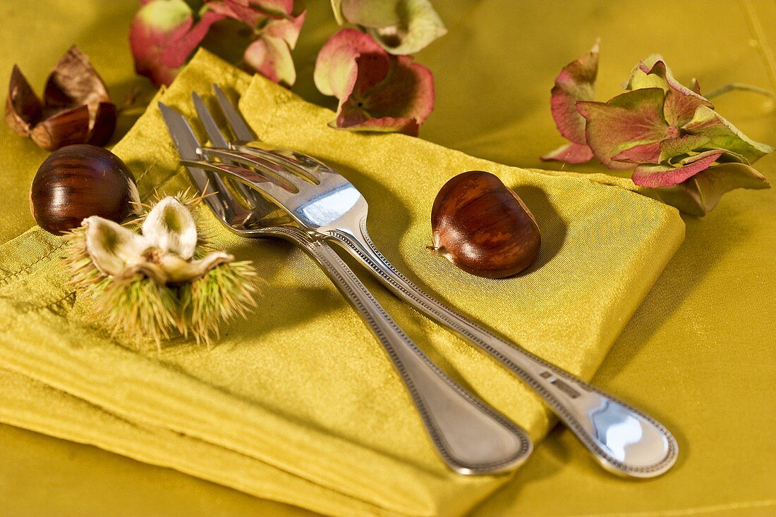Two forks and chestnuts on a napkin