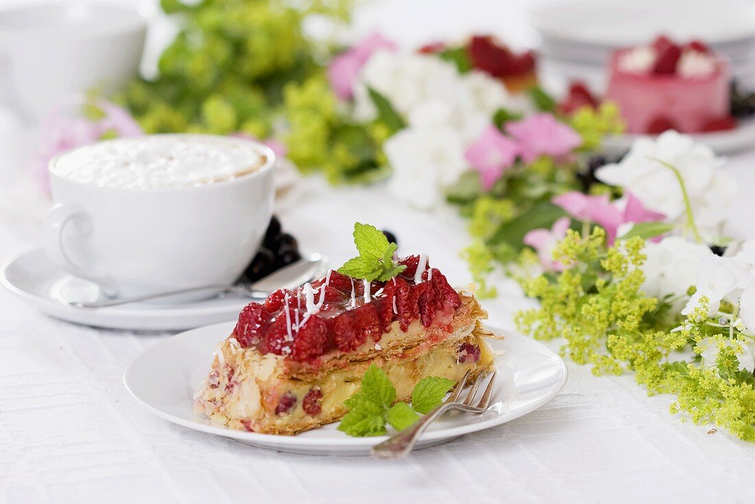 A piece of raspberry cake with cappuccino