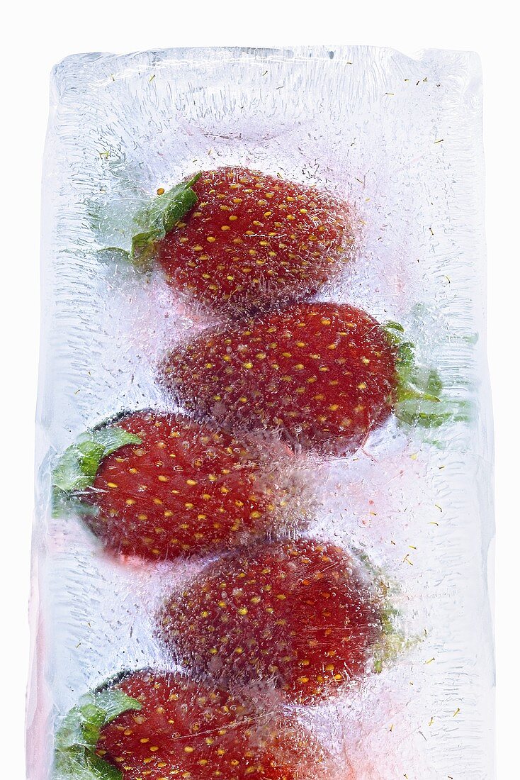 In einem Eisblock gefrorene Erdbeeren
