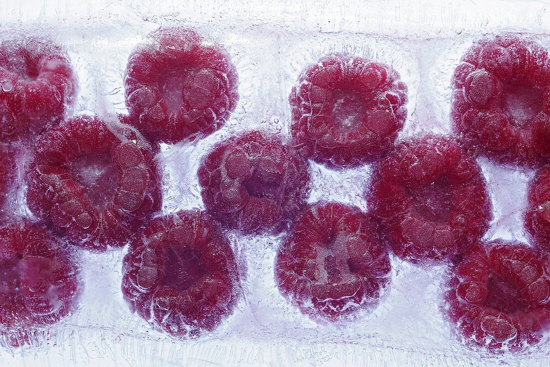Raspberries frozen in a block of ice (close-up)