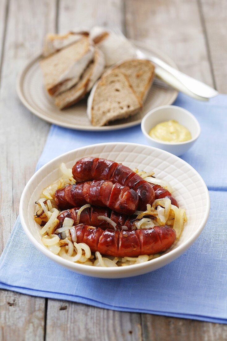 Bratwürstchen auf Zwiebeln mit Brot und Senf