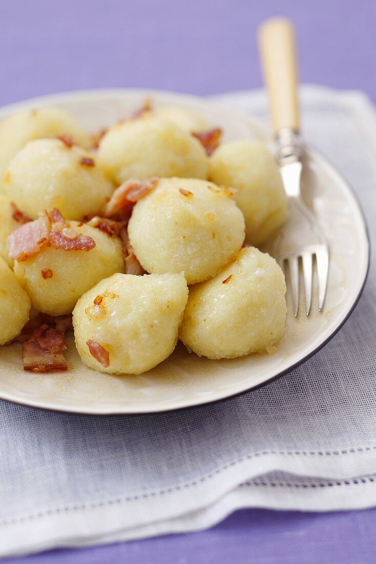 Kartoffelkösse mit Fleischfüllung und gebratenem Speck