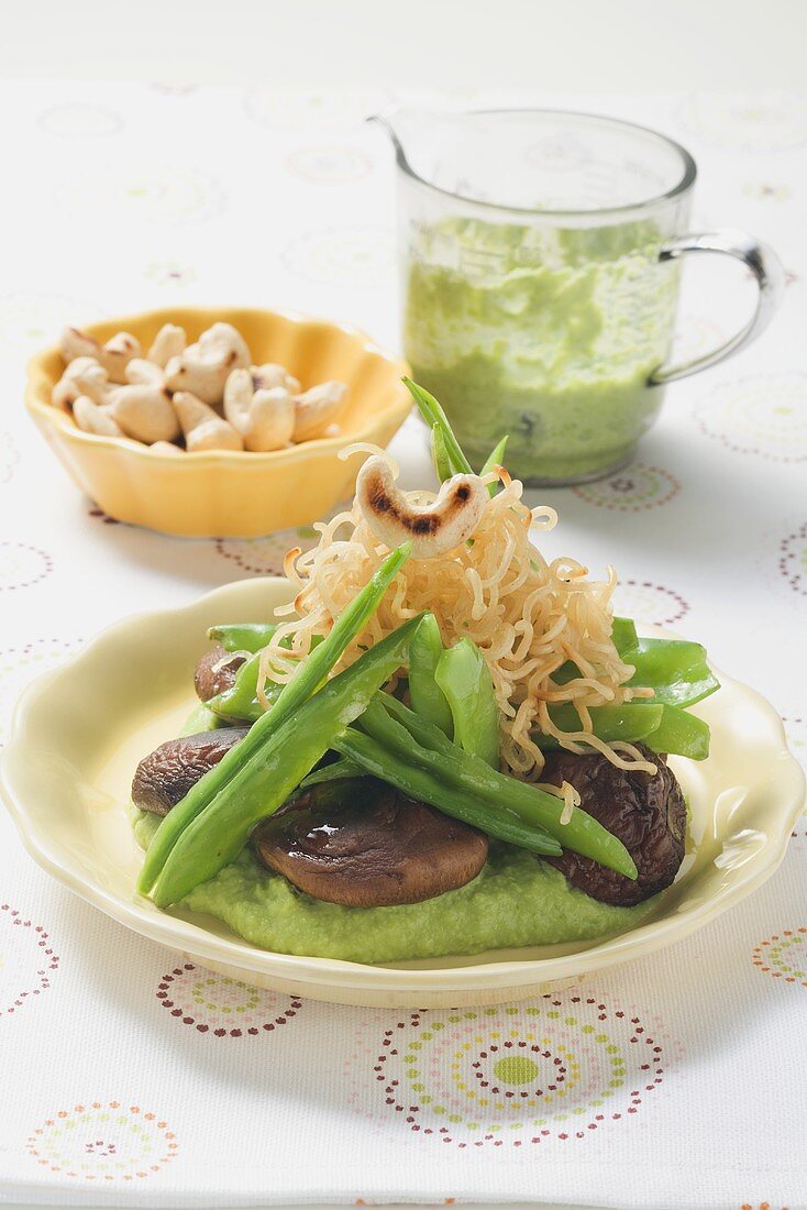 Fried mie noodles with shiitake mushrooms on pea puree