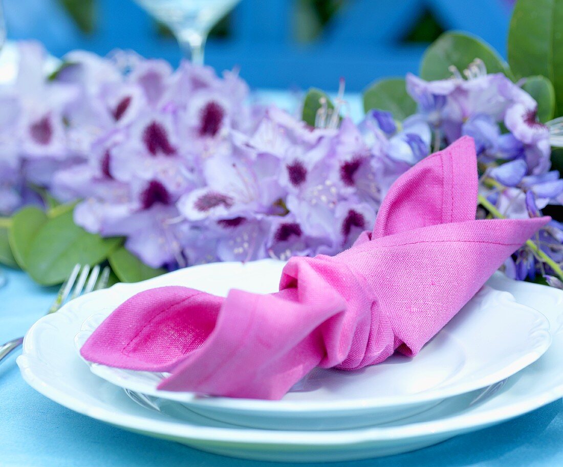 Gedeck mit Stoffserviette auf sommerlichem Tisch