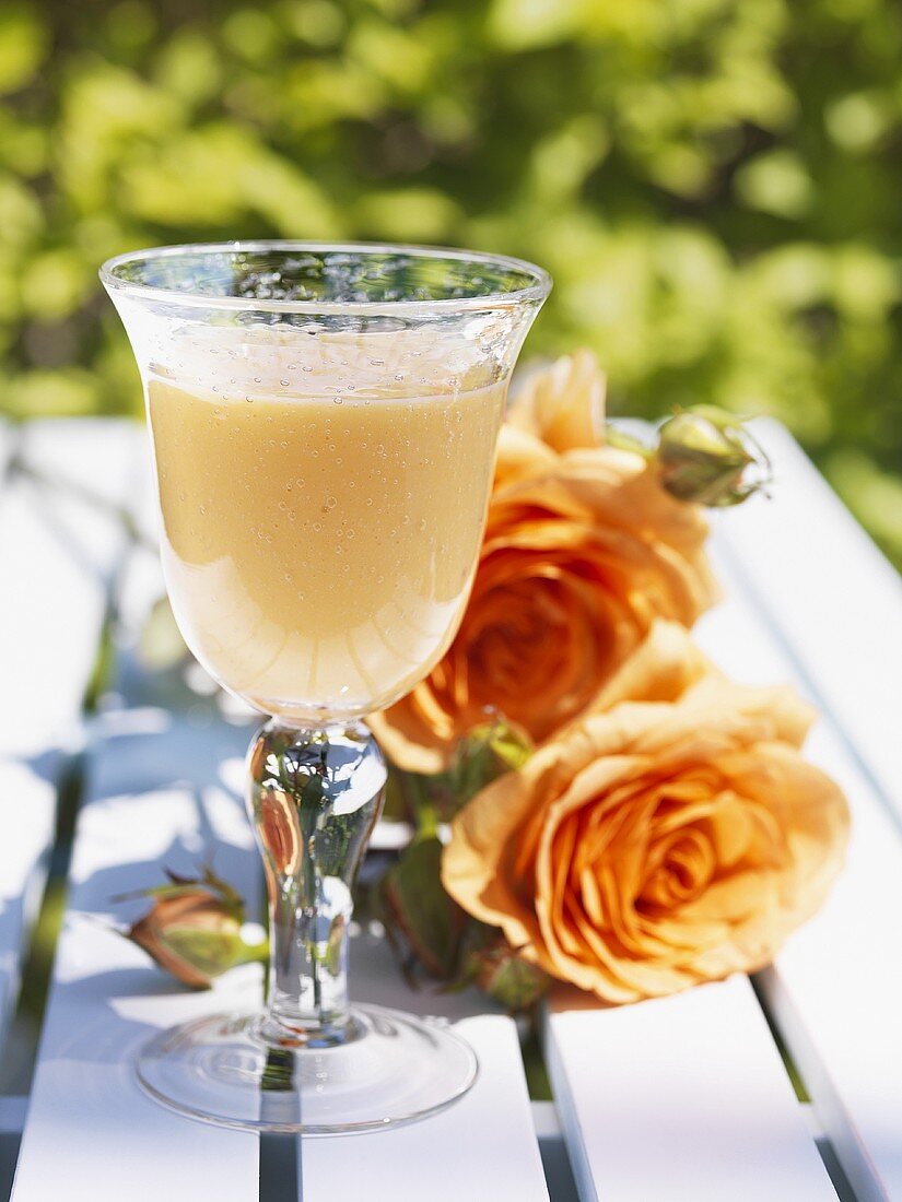Mango lassi on garden table with roses