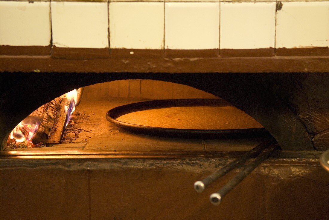 Farinata (chick-pea flatbread, Italy) in wood-fired oven