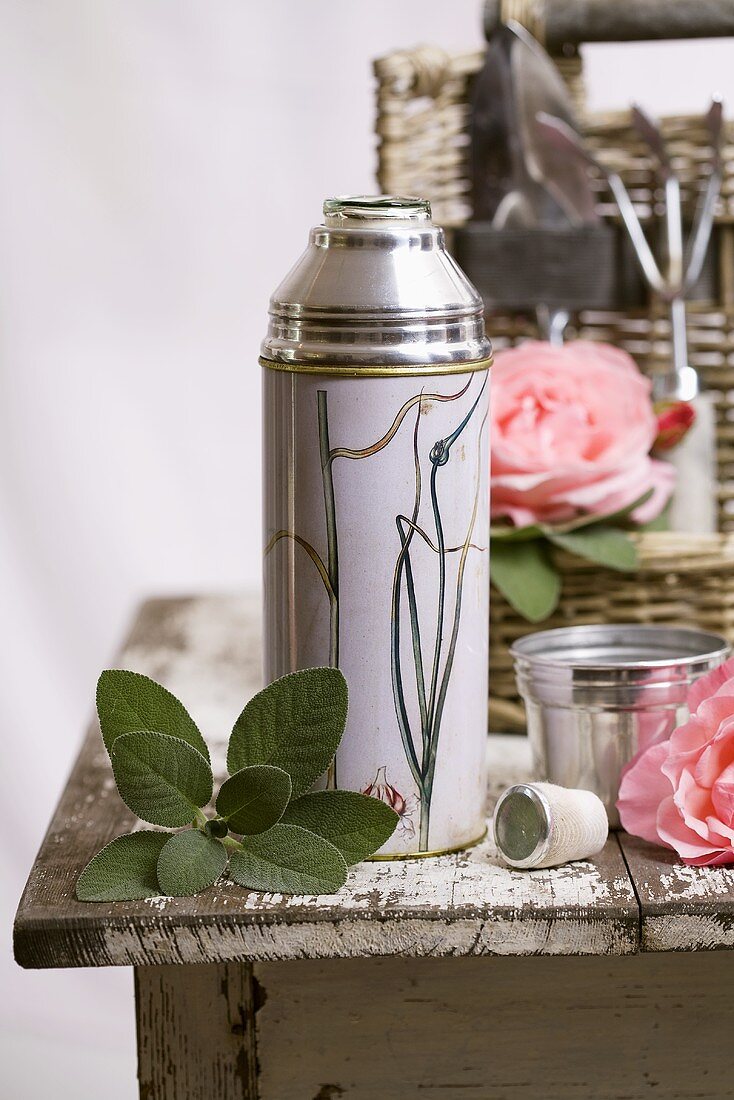 Thermos flask, sage leaves and roses