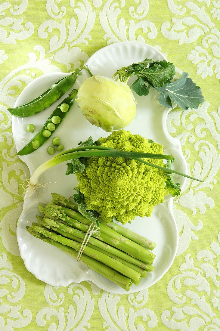Verschiedene grüne Gemüsesorten auf Porzellanteller