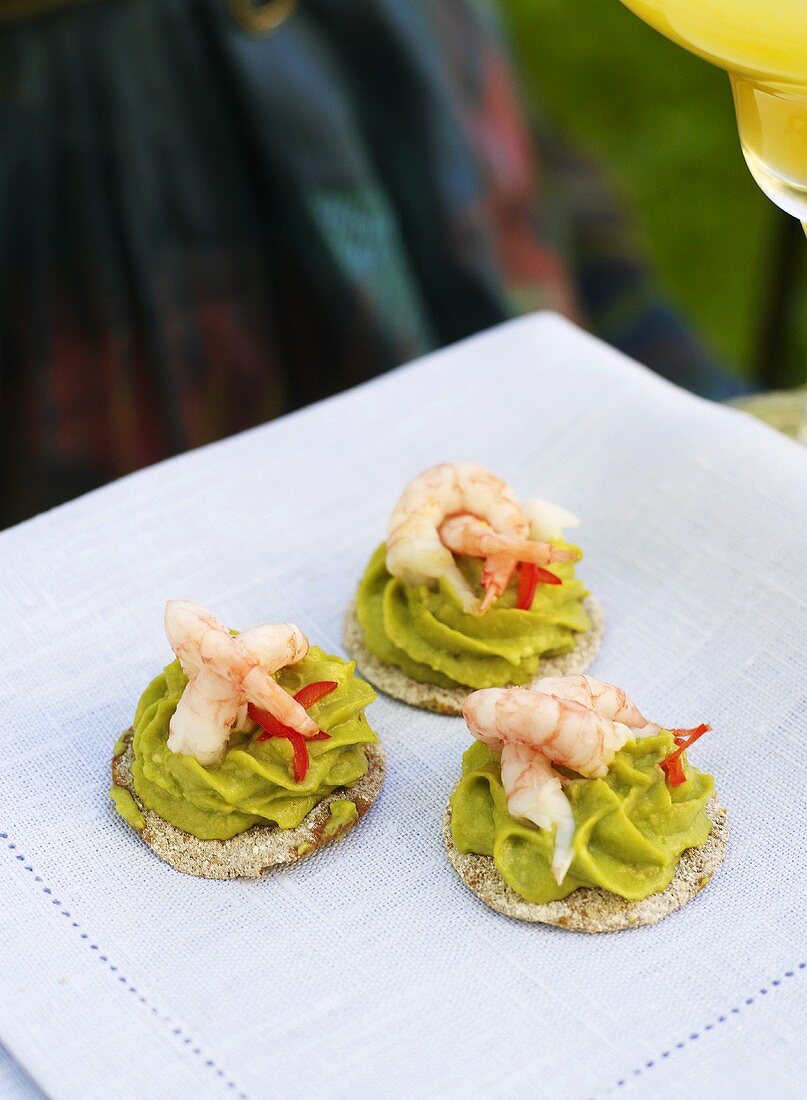 Guacamole and prawns on crackers