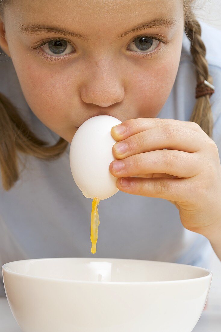 Child blowing a raw egg