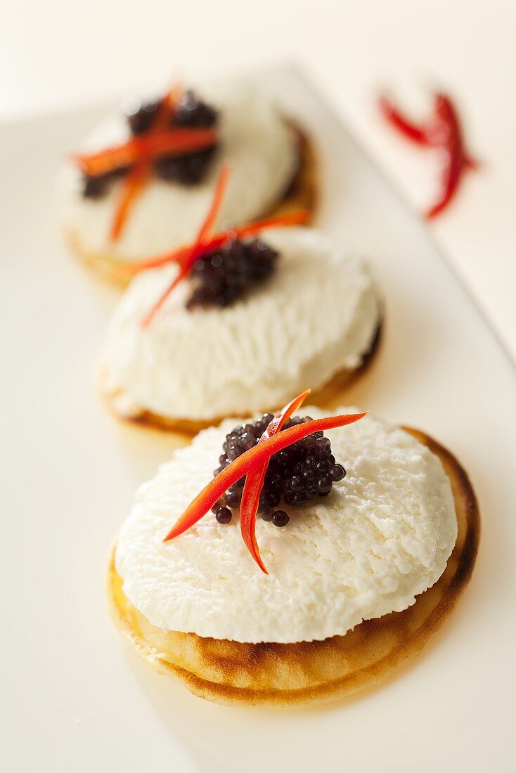 Blinis topped with goat's cheese and lumpfish roe