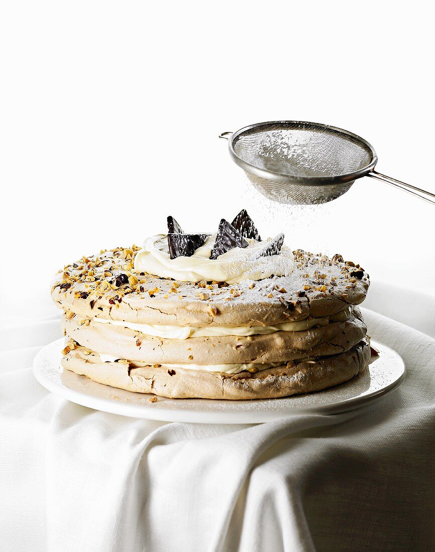 Dusting chocolate meringue with icing sugar