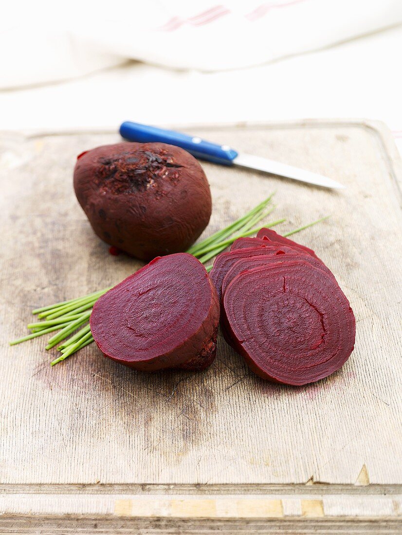 Cooked beetroot with chives on chopping board