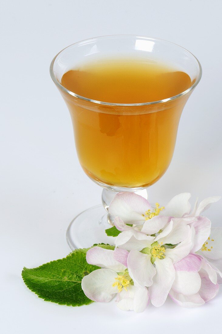 A glass of cider vinegar with apple blossom