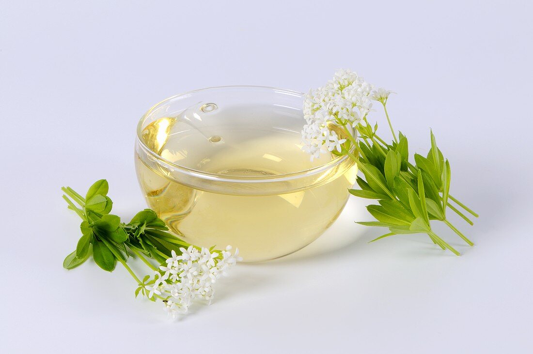 A cup of woodruff tea with flowers