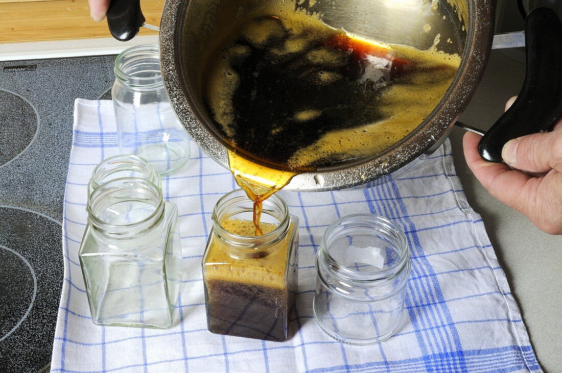 Pouring dandelion syrup into jars