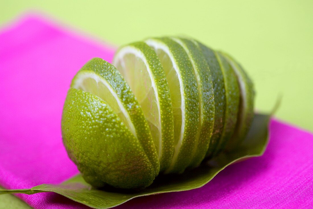 In Scheiben geschnittene Limette auf einem Limettenblatt