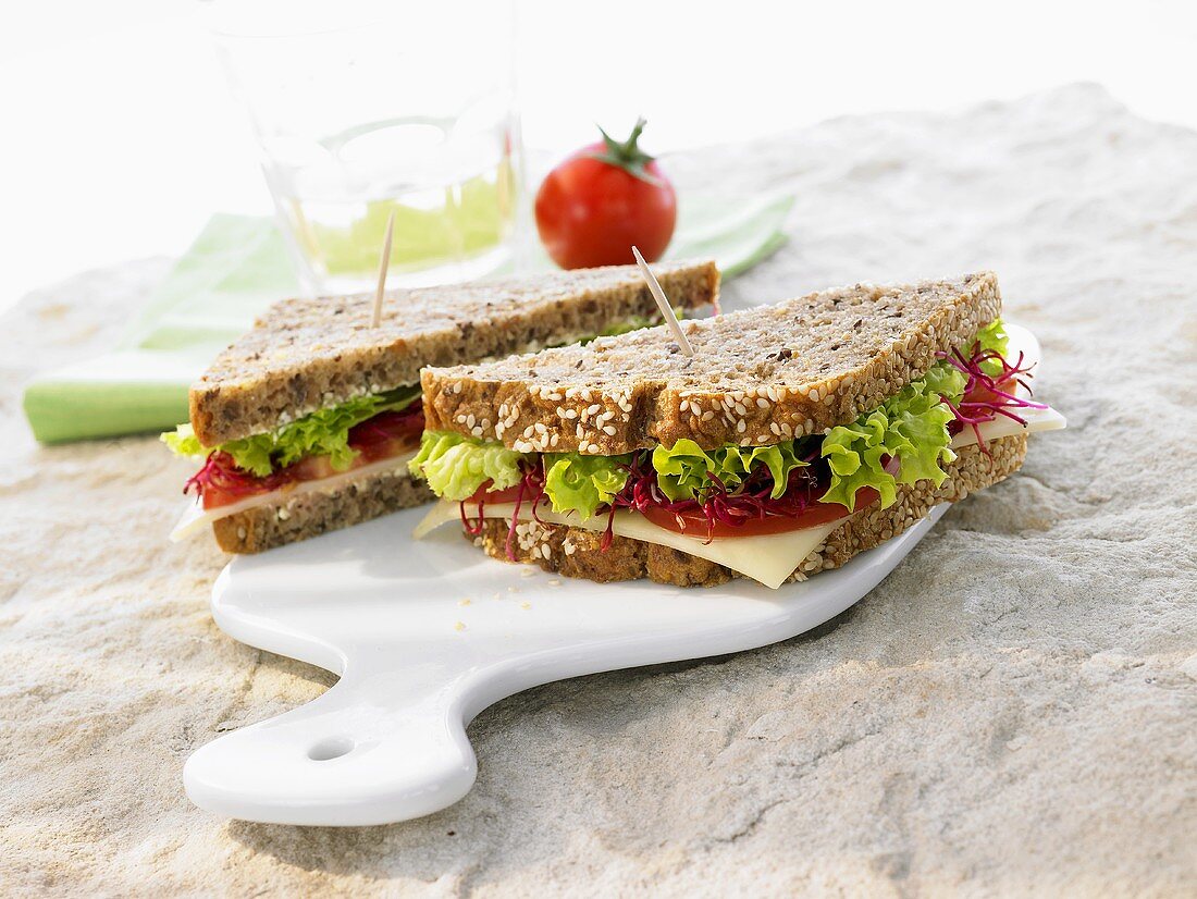 Käse-Vollkornsandwich mit Salat, Tomaten, Rote-Beete-Sprossen