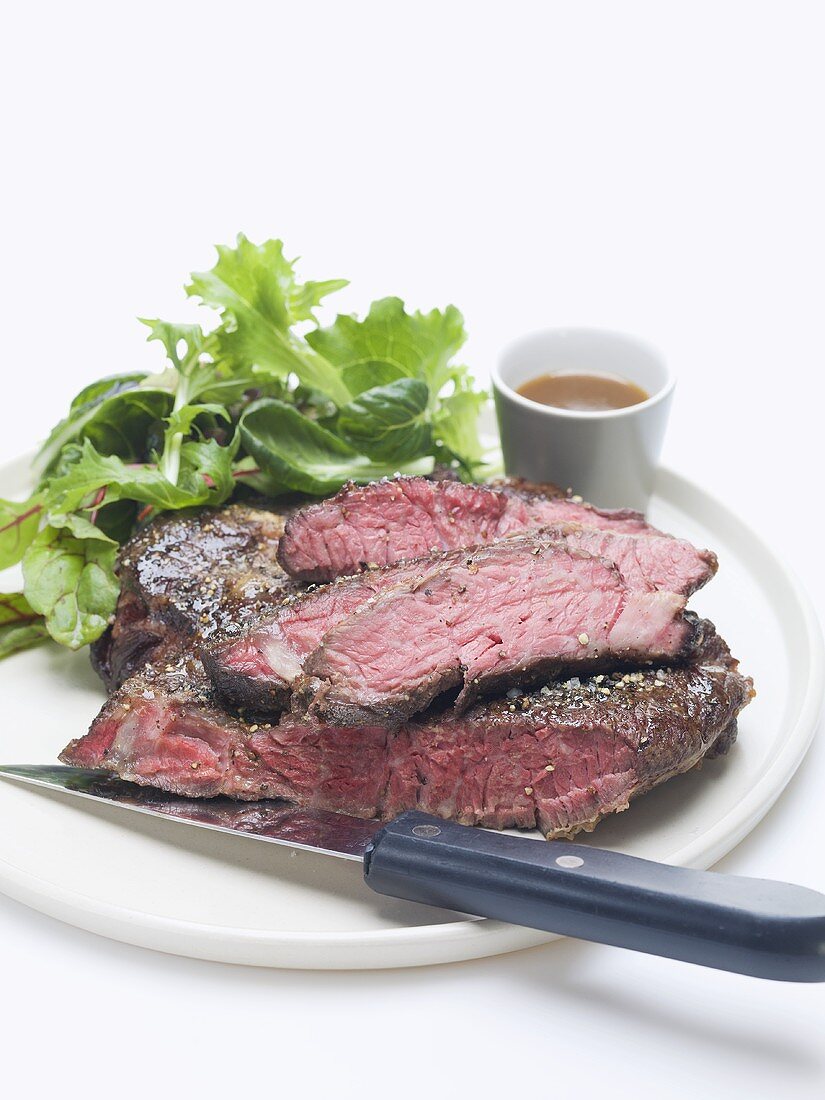 Beefsteak with green salad and sauce