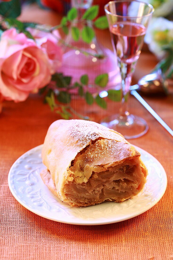 A slice of apple strudel on a festive table