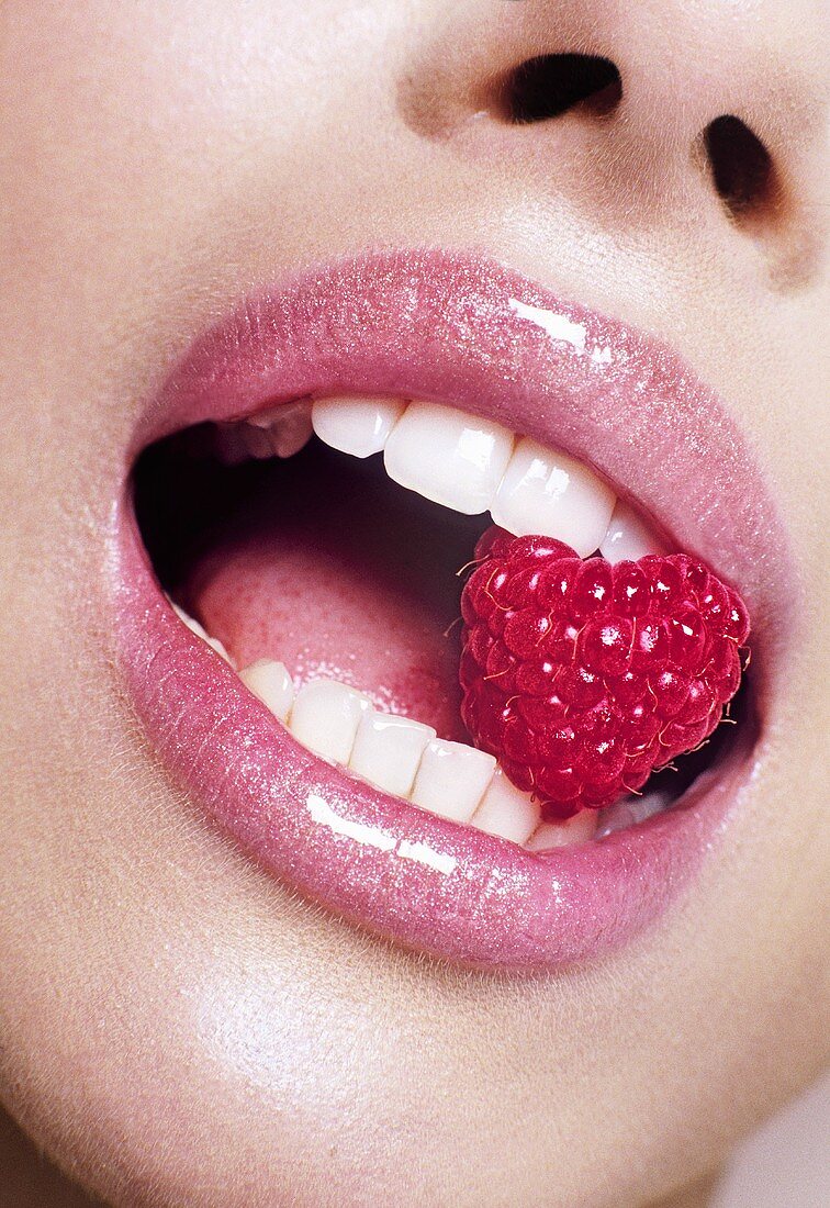 Woman with a raspberry in her mouth
