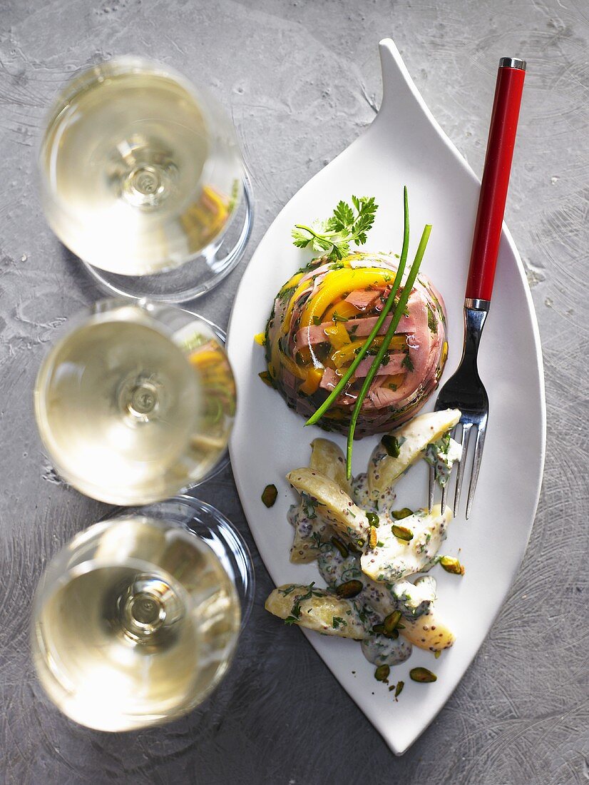 Sülzchen mit Schinken und Gemüse und drei Gläser Weißwein
