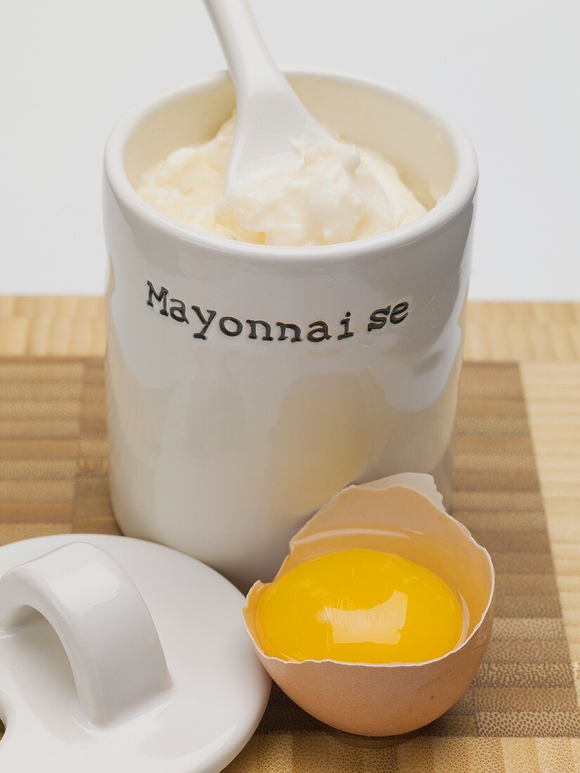 Mayonnaise im Becher, aufgeschlagenes Ei