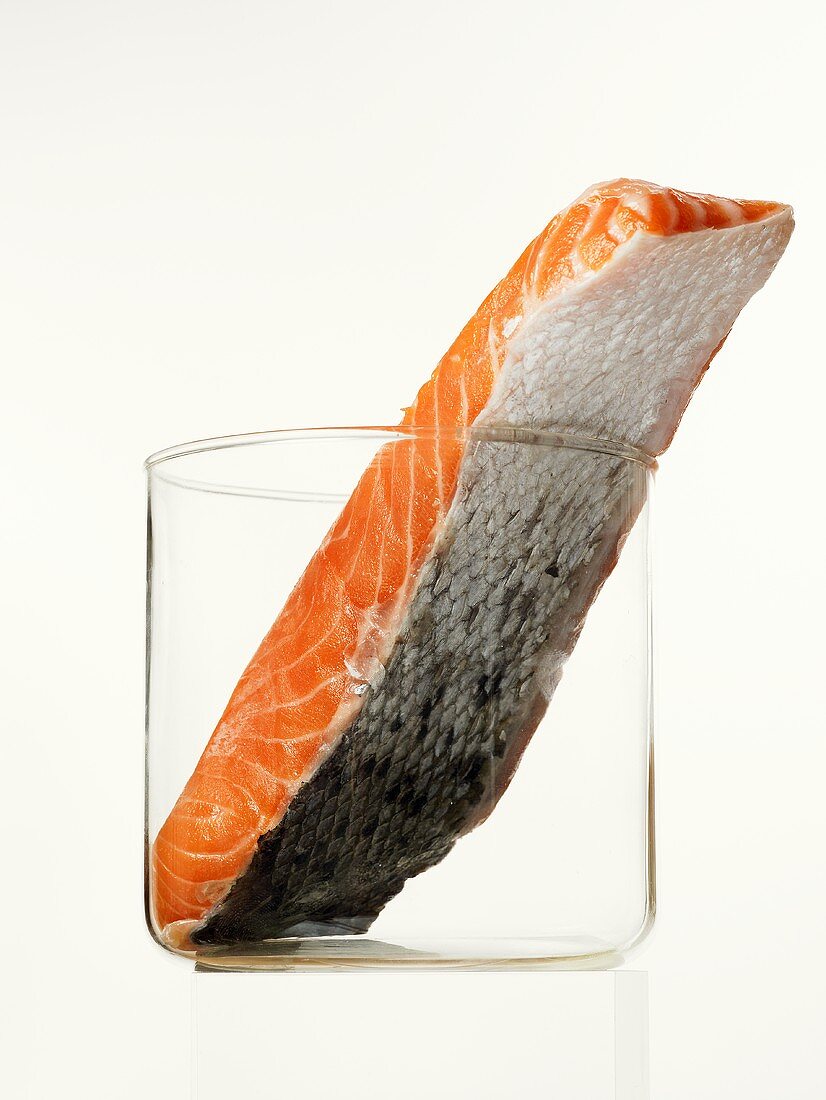 A slice of salmon with skin in a glass