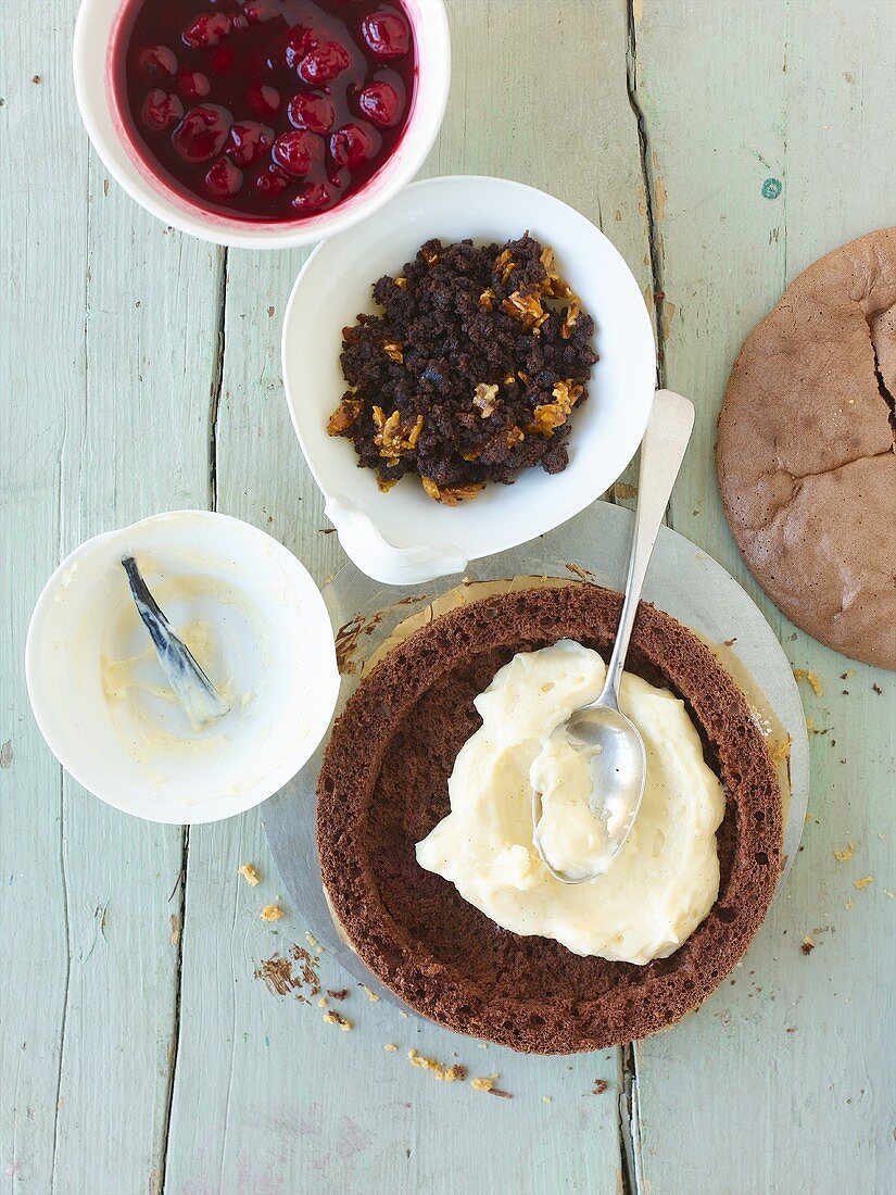 Schokoladenbiskuit mit Vanillecreme und Kirschen füllen