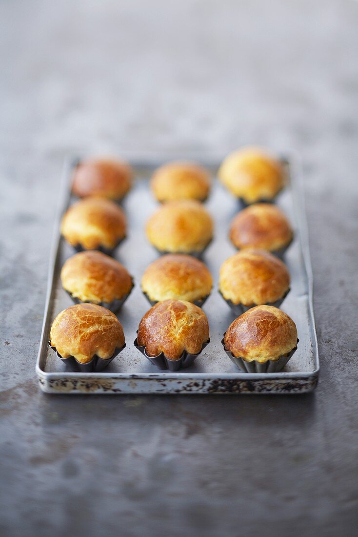 Brioches in kleinen Förmchen auf einem Backblech