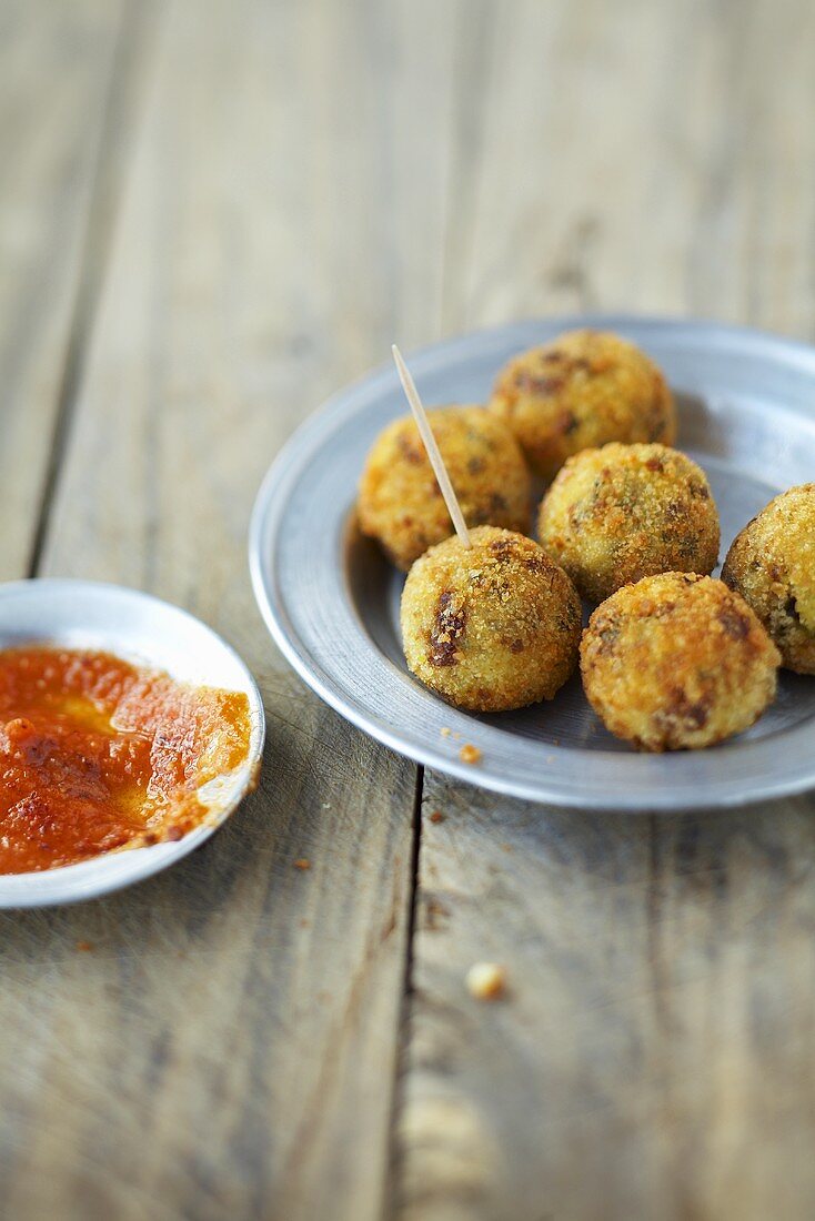 Frittierte Hirsebällchen mit Tomatensauce